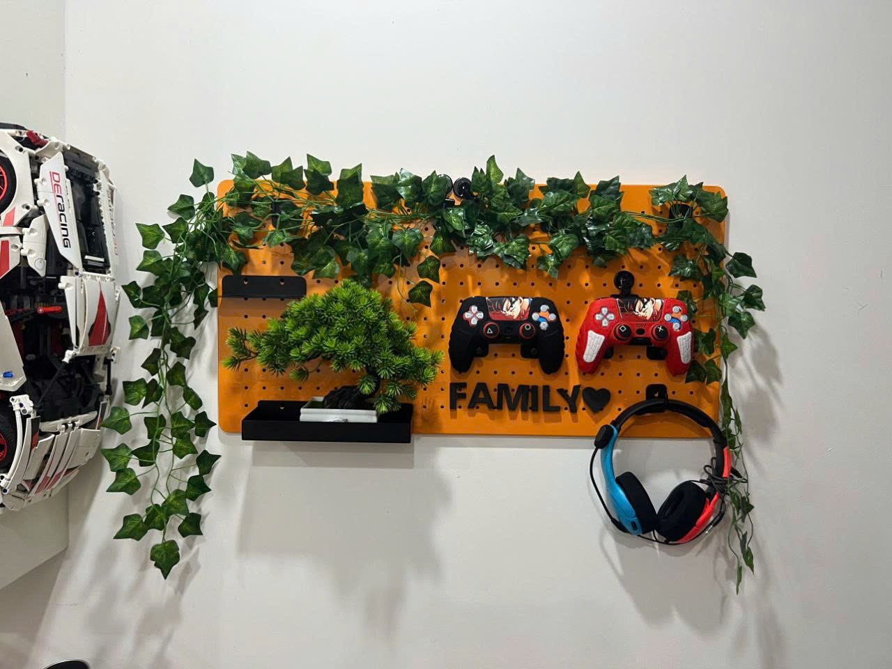 Bảng pegboard sắt sơn tĩnh điện m&agrave;u cam treo tường, trang tr&iacute; tay cầm game, tai nghe v&agrave; c&acirc;y cảnh giả, tạo kh&ocirc;ng gian gọn g&agrave;ng v&agrave; c&aacute; t&iacute;nh
